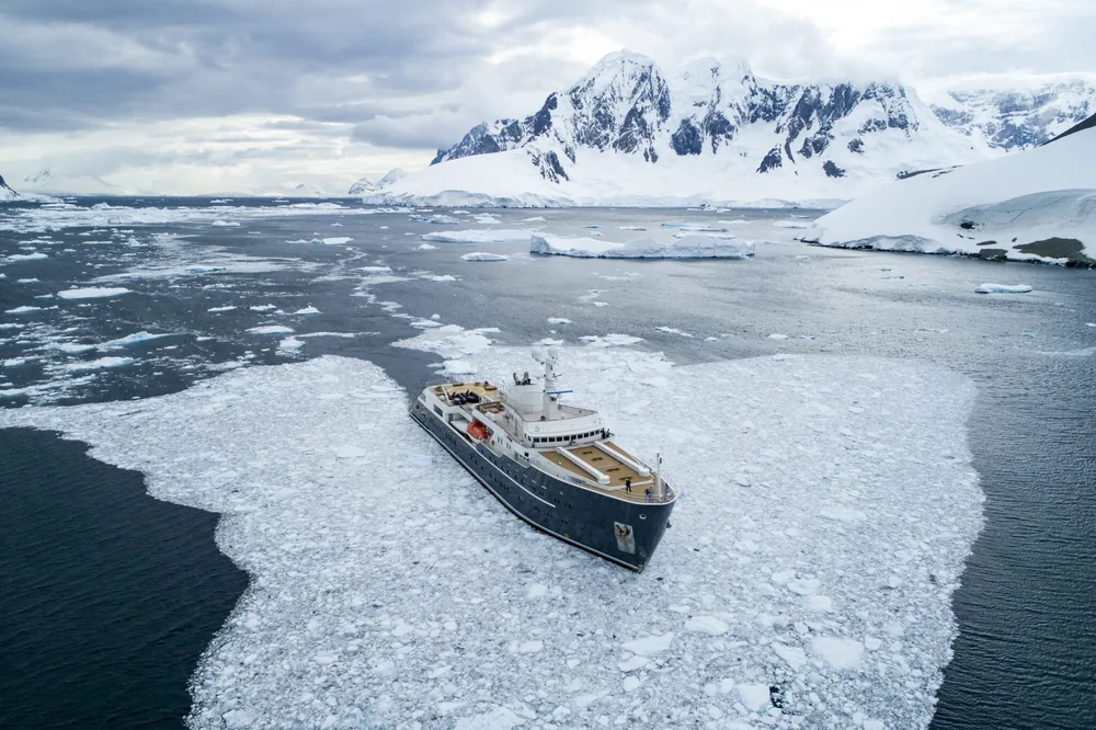 The expedition yacht Legend threading through pack ice off the Antarctic Peninsula, seen from above