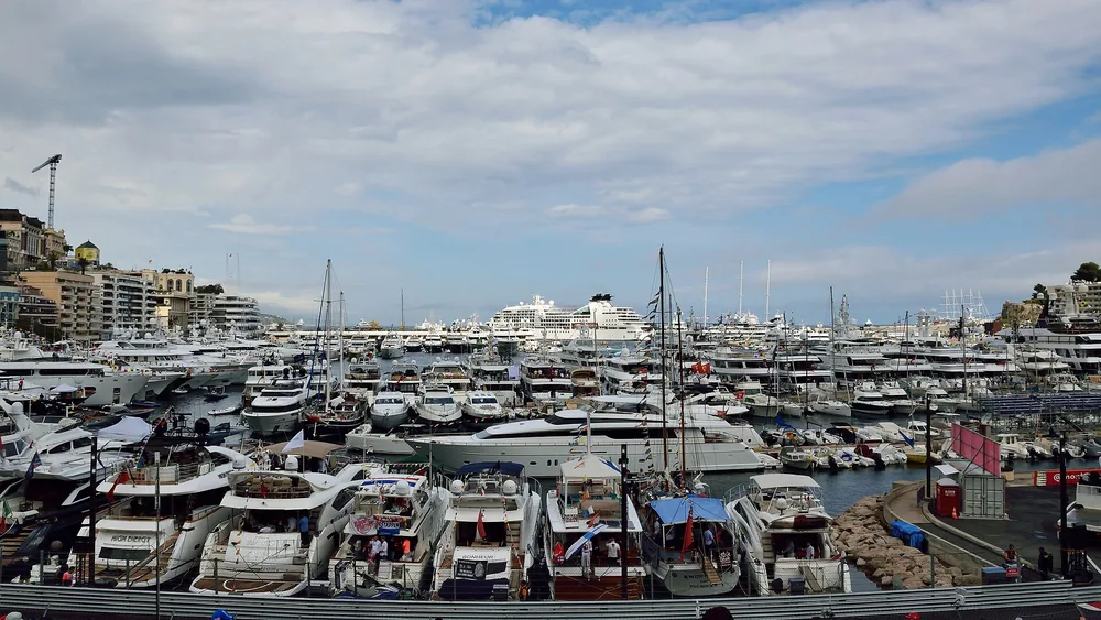 Monaco harbour packed with yachts on Grand Prix race day, the town rising behind