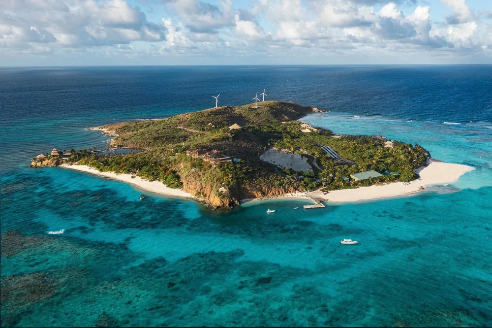 Necker Island from the air: green hills ringed by white beaches and turquoise reef