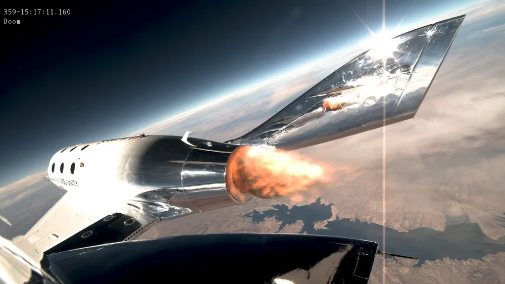 A spaceplane fires its rocket motor high above the clouds, seen from a boom camera on its tail