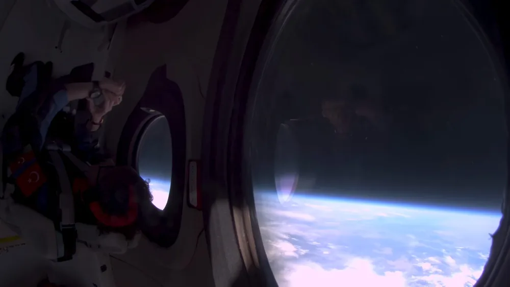 The curve of the Earth and the black of space through an oval spacecraft cabin window
